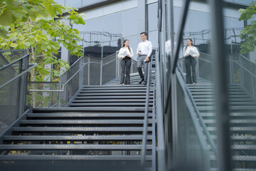 Business colleagues walking downstairs outdoors - 775233123