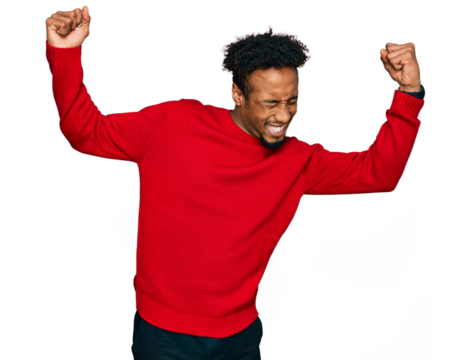 Young african american man with beard wearing casual winter sweater very happy and excited doing winner gesture with arms raised, smiling and screaming for success. celebration concept.