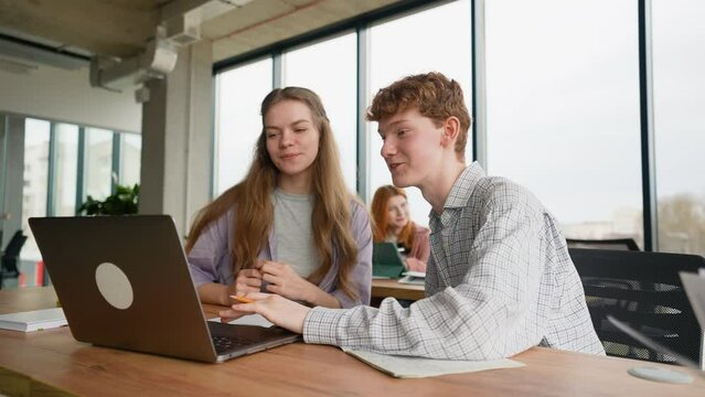 University students in library use laptop computer for a research