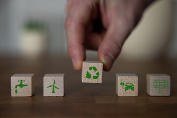 Green and eco building concept. wooden cubes with green building symbols on the natural background....