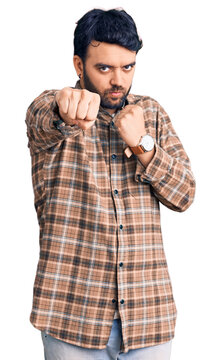Young hispanic man wearing casual clothes punching fist to fight, aggressive and angry attack, threat and violence