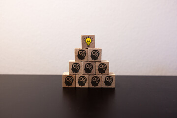 Concept creative idea and innovation. Hand picked wooden cube block with head human symbol and...