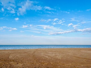 dune at the sea shore, blue sky with white clouds, idyllic seascape
