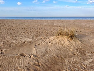 dune at the sea shore, blue sky with white clouds, idyllic seascape