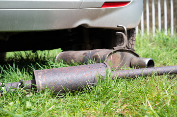 Broken exhaust and muffler of a car, rusted silencer fallen down on the road, breakdown of vehicle - 775242120