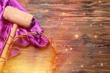 Crown of thorns with purple cloth and hammer on wooden background. Good Friday concept