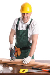 Mature carpenter sawing wooden plank at table on white background