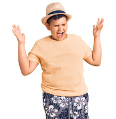 Little boy kid wearing summer hat and hawaiian swimsuit celebrating mad and crazy for success with...