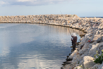 Larnaca, Cyprus - 1 April 2023: Fisherman in harbour in Larnaca