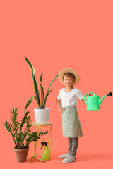 Cute little gardener with watering can and plants on orange background
