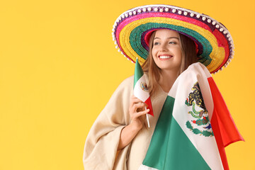 Young woman in sombrero hat with Mexican flags on yellow background