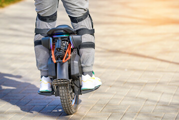 Man riding EUC electric wheel on sidewalk closeup. Man commuting on electric monowheel with...