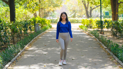 Young woman walking in the park, also known as jogging or morning walk, outdoor fitness concept
