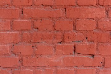 Red brick wall background. Close-up view of old painted red brick wall surface covered with cracks and scratches. Copy space for your text and decorations. Abstract backdrop theme.