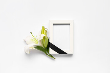 Beautiful lily flowers with blank funeral frame on white background