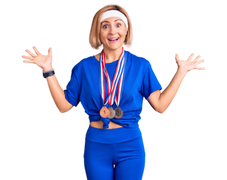 Young blonde woman wearing winner medals celebrating victory with happy smile and winner expression with raised hands
