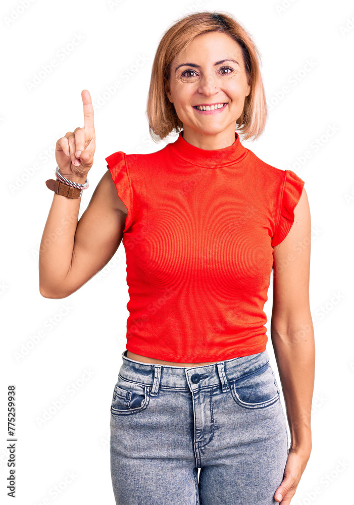 Sticker Young blonde woman wearing casual clothes showing and pointing up with finger number one while smiling confident and happy.