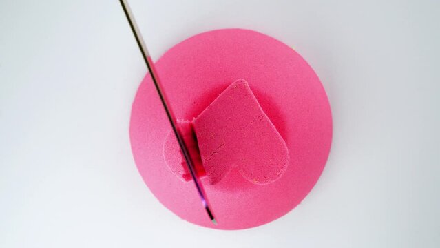 Kinetic sand cutting with a knife on a white background. ASMR sounds. Very Satisfying and Relaxing Kinetic Sand ASMR video. Cutting anti stress macro close up colorful Kinetic Sand with a Knife.