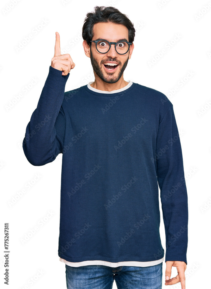 Sticker young hispanic man wearing casual clothes and glasses pointing finger up with successful idea. exite