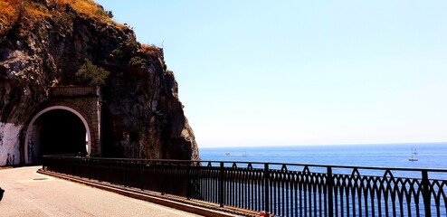 The road running along the shore of the Mediterranean Sea through a rock. Summer sunny day. - 775267953