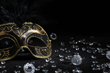 Close-up view of Carnival gold mask with diamonds on black background.