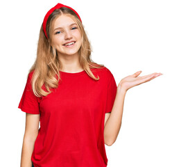 Beautiful young caucasian girl wearing casual red t shirt smiling cheerful presenting and pointing with palm of hand looking at the camera.