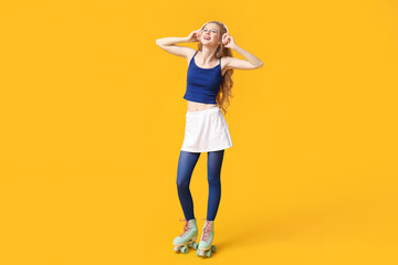 Beautiful young woman in vintage roller skates with headphones on yellow background