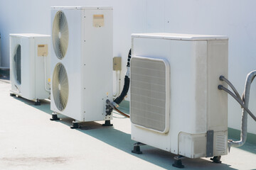 Air conditioner compressor installed on the wall of a building, along with industrial air...