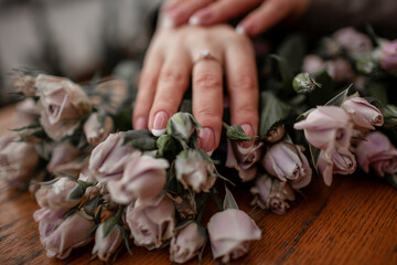 close-up of female hands holding a bouquete with roses