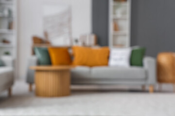 Blurred view of living room with 3D painting, sofa and table