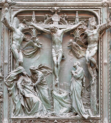 MILAN, ITALY - SEPTEMBER 16, 2024: The detail from main bronze gate of the Cathedral -   Crucifixion by Ludovico Pogliaghi (1906).