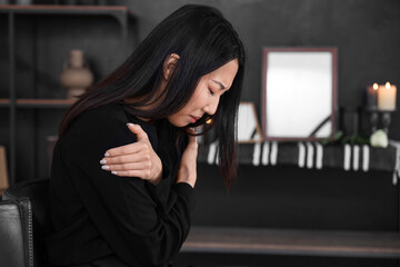 Mourning young Asian woman at funeral