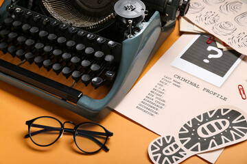 Retro typewriter, eyeglasses and criminal files on color background, closeup