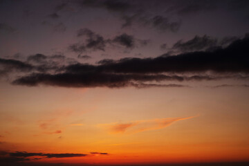 Obraz premium Orange sky background with dark clouds at sunset on a summer evening 