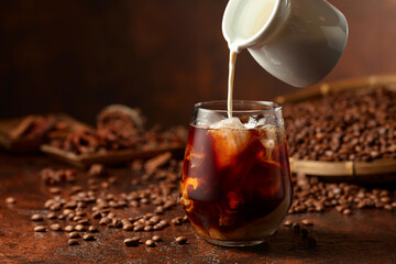 Iced coffee with cream on a brown table.