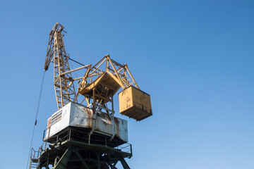 Fototapeta na wymiar Port industrial cranes at river unloading depot on clear sunny day