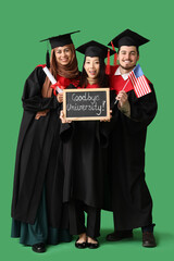 Graduate students holding diploma, USA flag and chalkboard with text GOODBYE UNIVERSITY on green background