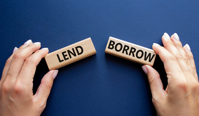 Lend or Borrow symbol. Concept word Lend or Borrow on wooden blocks. Businessman hand. Beautiful deep blue background. Business and Lend or Borrow concept. Copy space