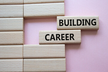 Building Career symbol. Wooden blocks with words Building Career. Beautiful pink background....