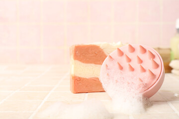Hair scalp massager with shampoo bar on pink tile background