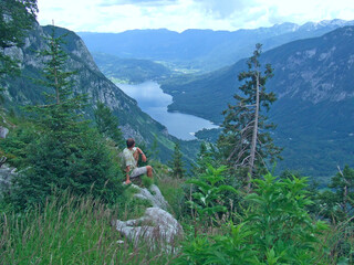 Man watching natural landscape. Traveller having rest near mountainous lake