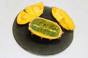 Cut kiwano fruit on plate. Ripe fruit of Cucumis metuliferus. jelly melon