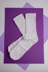 Pair of white socks on a colored background, flat lay. Place for text. Women's and men's socks