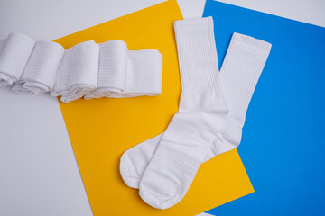 Pair of white socks on a colored background, flat lay. Place for text. Women's and men's socks