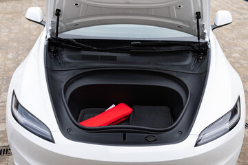 Car trunk for charging cables, front of the car. Front trunk of white electric vehicle , front...