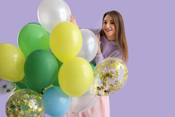 Young woman with colorful balloons on lilac background