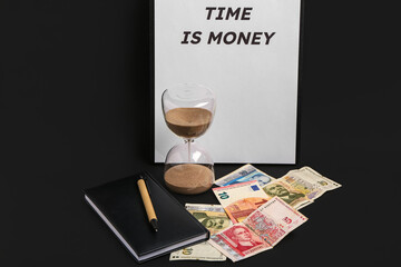 Clipboard with text TIME IS MONEY, hourglass and money on black background
