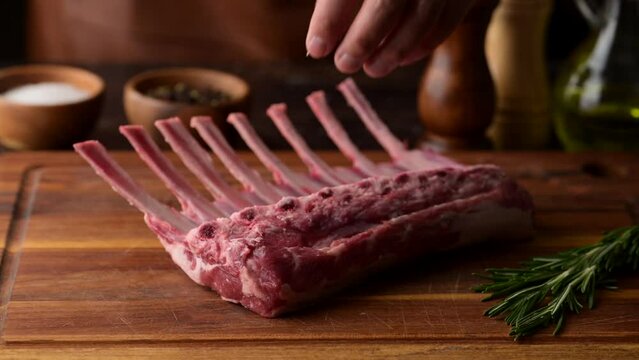 chef cutting fresh lamb chop on wooden cutting board