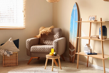 Interior of living room with surfboard and coffee table with fresh juice. Summer composition