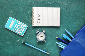 Notebook with text TO DO LIST, calculator and alarm clock on green background. Time management...